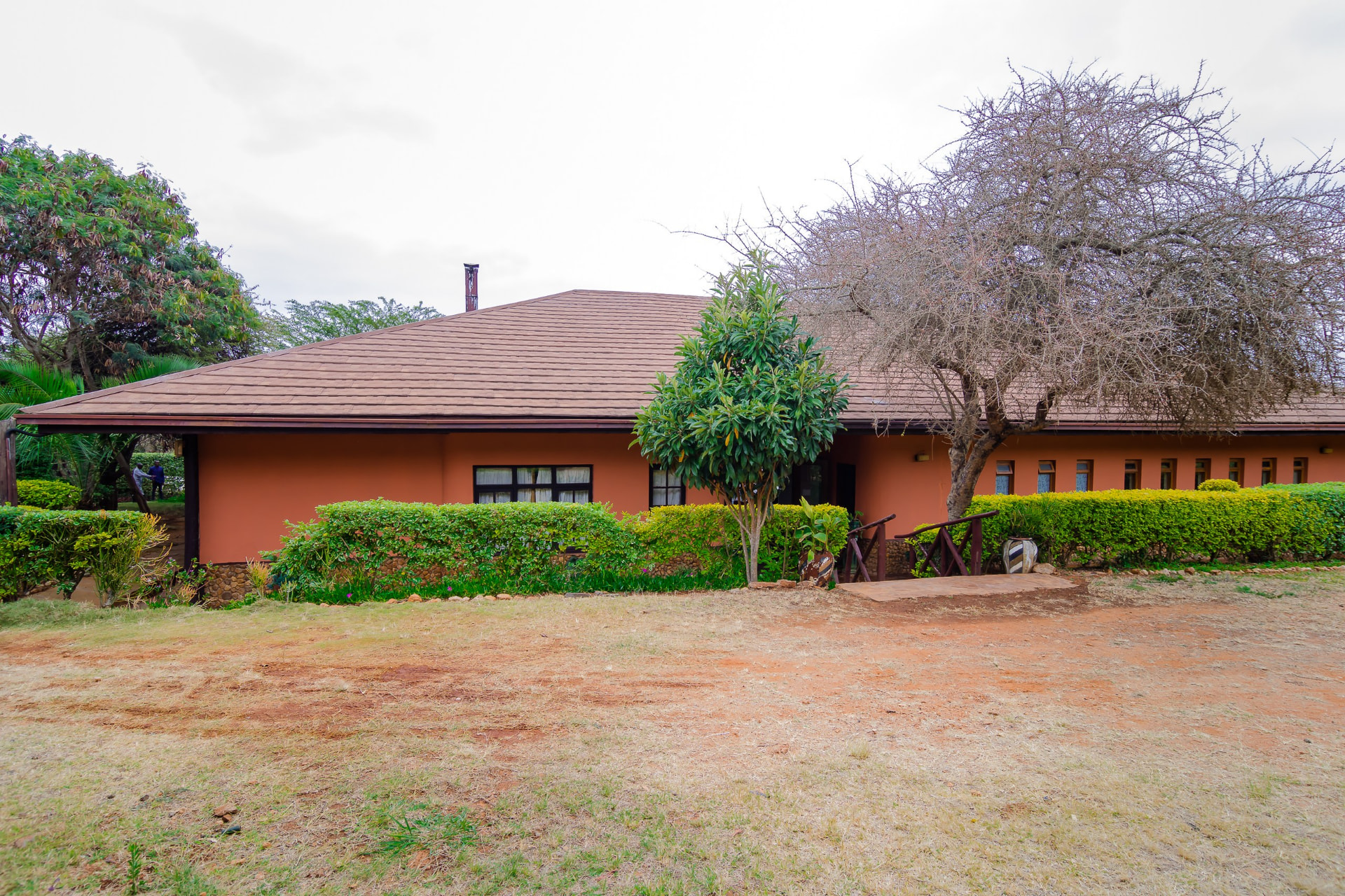 Lodge building with warm ochre walls and hedged gardens