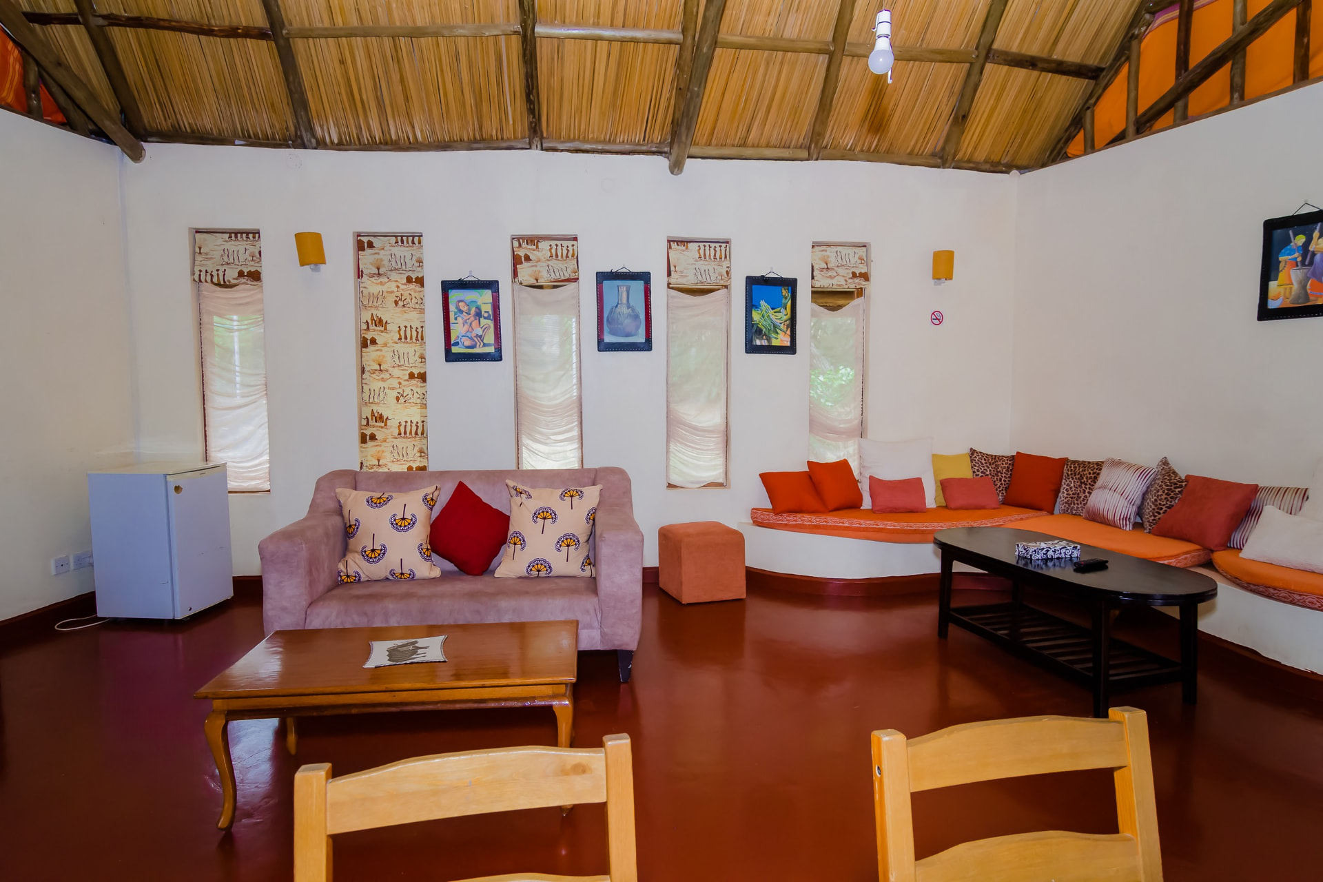 Open lounge under a thatched ceiling with local artwork