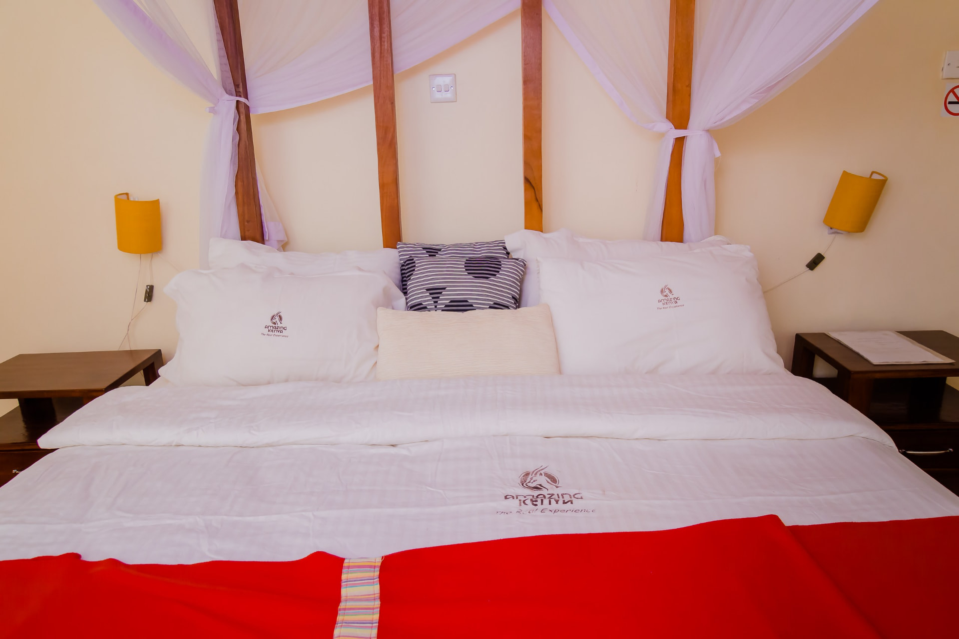 Bedroom with a mosquito-net canopy bed and branded linen