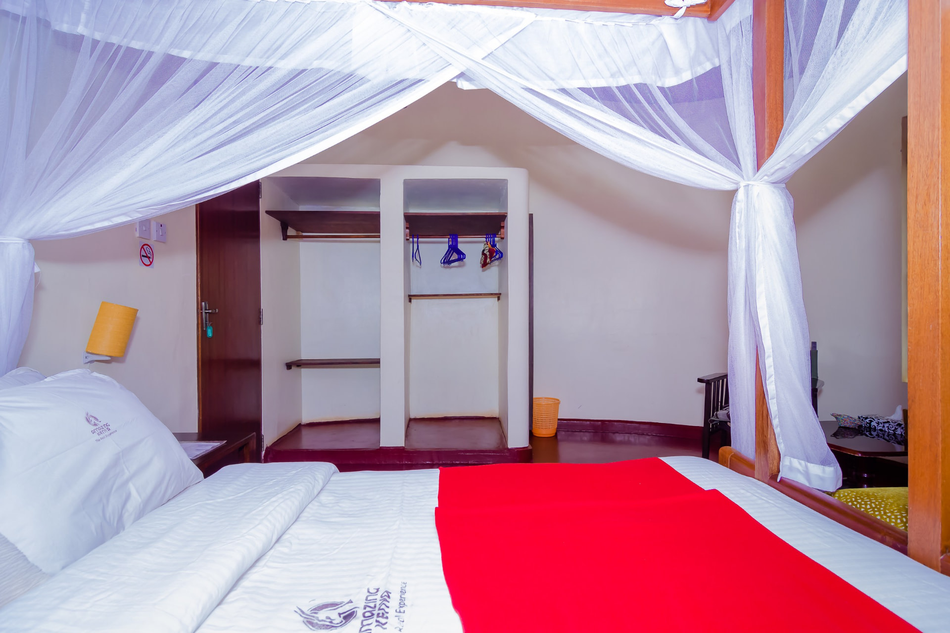 Bedroom with canopy bed, wardrobe and red table runner