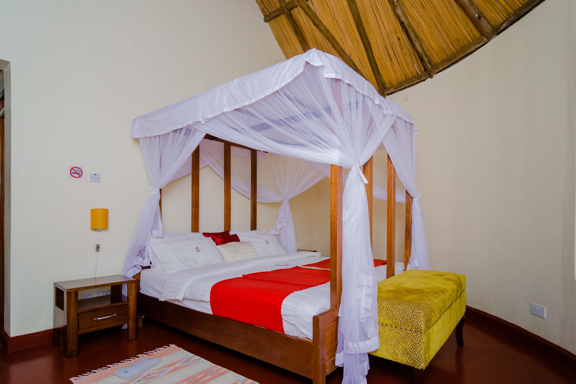 Bedroom with a canopy bed and mustard ottoman