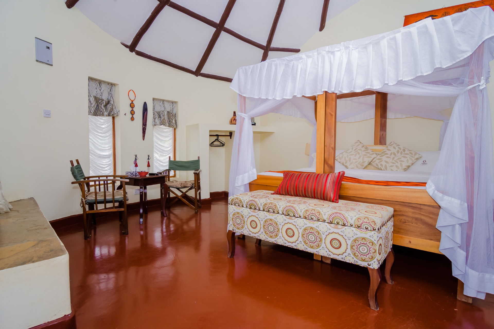 Bedroom with a patterned bench and exposed beams