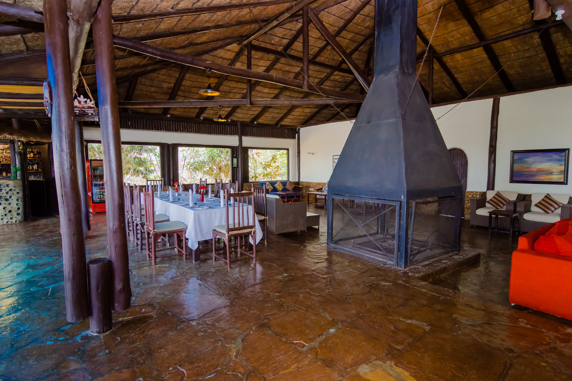 Dining hall set for service beside a stone fireplace